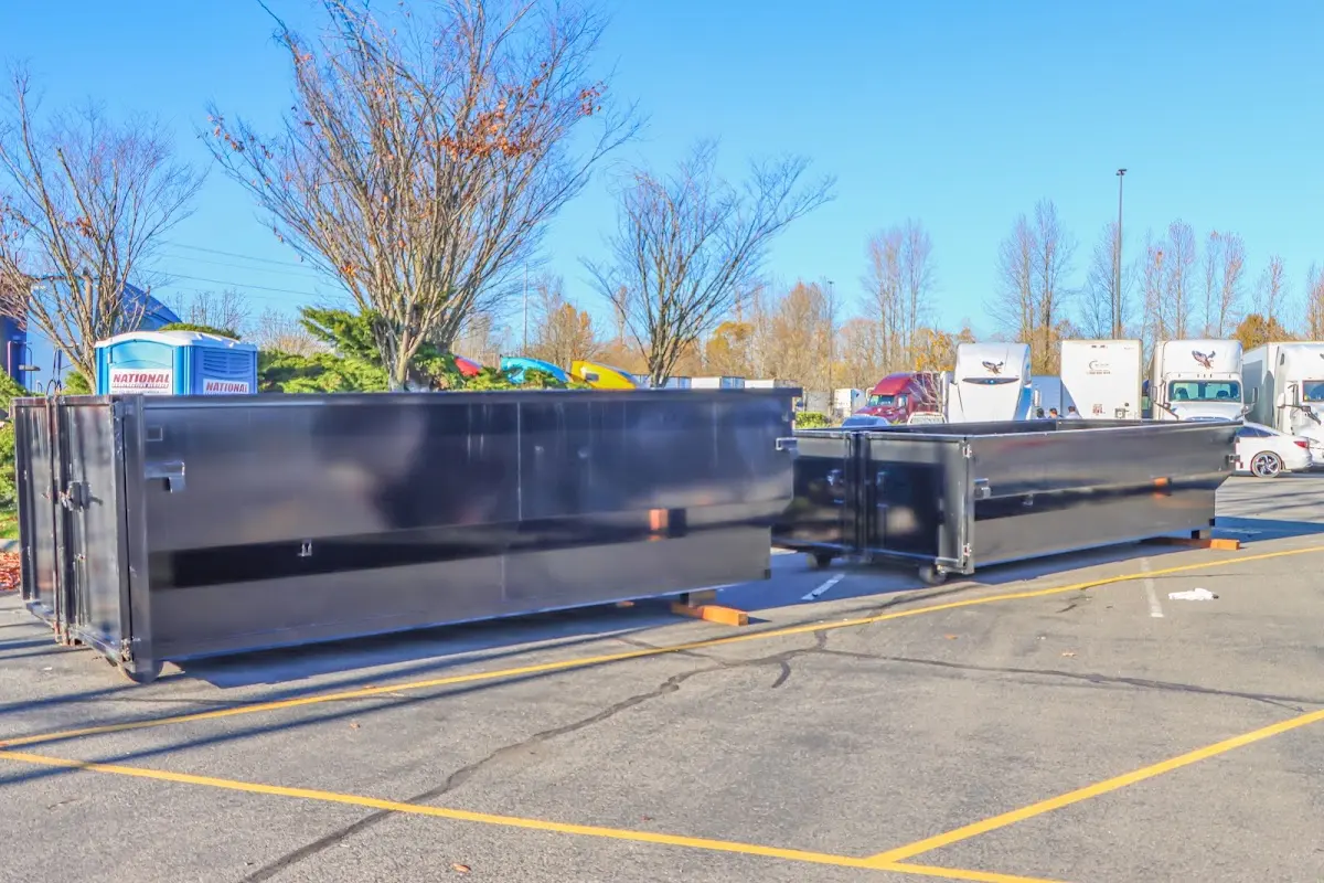 Professional dumpster rental service with roll-off container on residential driveway in Vicksburg